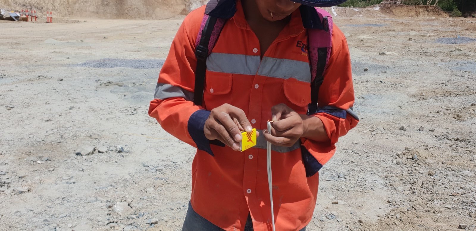 Hands lighting a safety fuse during shotfirer training.