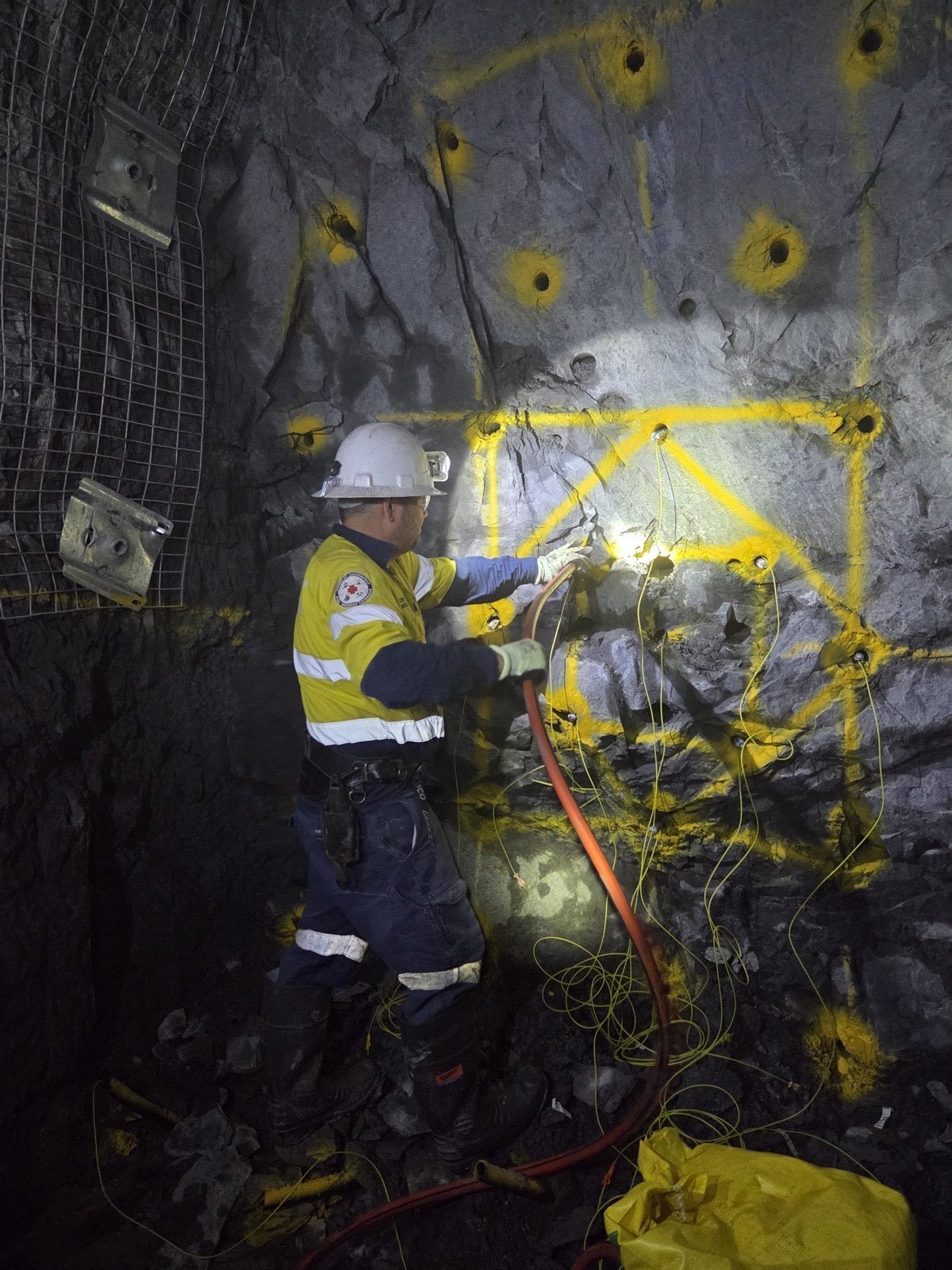 Charging drilled holes in a burn cut in an underground development heading.